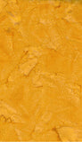 A close-up of a textured yellow gold with mottled lighter and darker areas, cotton batik fabric