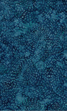 A close-up of a blue patterned fabric or material with an allover organic dotted texture in varying teal and navy tones.