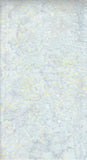 A close-up of a light gray cotton batik fabric with random scattered small yellow and aqua spots.
