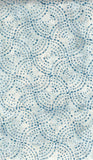 Patterned cotton batik fabric with blue and white circles on a textured background
