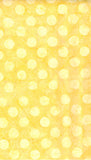 A close-up of a yellow batik cotton fabric or material with a repeating pattern of soft, slightly translucent pale yellow circles.