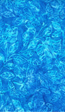 A close-up of a blue batik fabric with a tonal leaf and floral pattern in various shades of bright and medium blue.