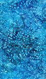 Blue batik fabric with a repeating leaf and floral pattern in various shades of blue.