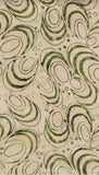 Patterned cotton batik fabric with green and beige swirls on a textured background