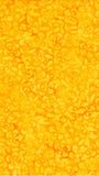 A close-up of a bright yellow-orange cotton batik fabric with a repeating floral or paisley-like woven pattern.