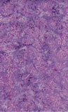 A close-up of a purple and pink patterned batik fabric or material swatch with an allover floral or lace-like print.