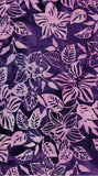 A close-up of a batik fabric pattern featuring stylized pink and lavender flowers and leaves on a dark purple background.