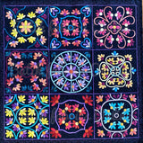 A square quilt featuring a 3x3 grid of colorful floral and geometric applique motifs on a dark navy background.