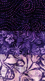 Three horizontal bands of batik fabric in shades of purple, featuring polka dot patterns, floral motifs, and abstract bird designs.