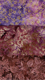Three stacked batik fabric swatches showing different floral patterns and color variations in purple, pink, and brown tones.