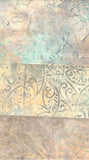 A close-up of a patterned batik fabric with horizontal bands of abstract floral and scroll motifs in beige, tan, muted teal, and brown tones.