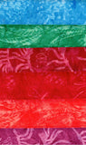 Collection of cotton batik fabric swatches in blue, green, red, and pink with floral patterns.